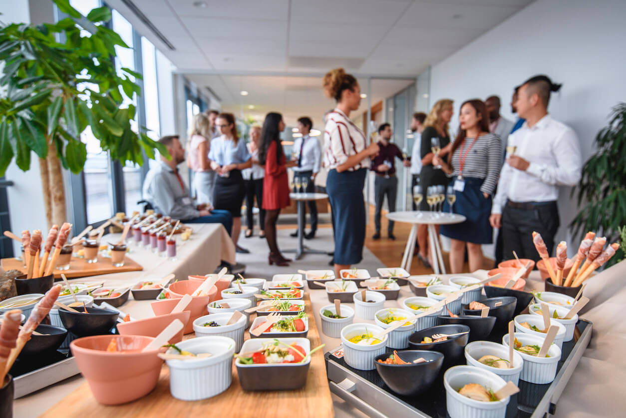 Focus on foreground gourmet small dishes and desserts on buffet tables at new business launch celebration event