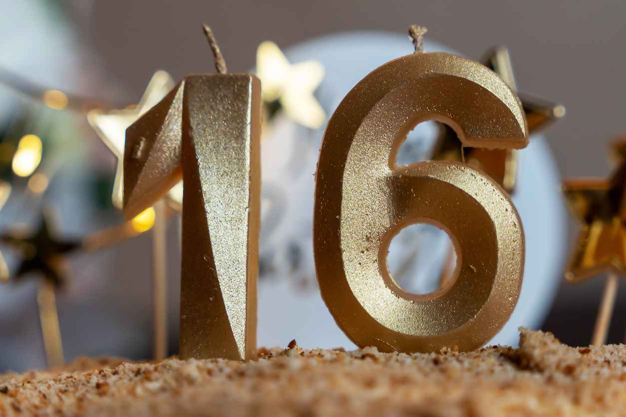 Celebrating a sweet sixteen with golden number candles and star decorations on a cake